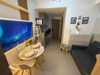 a living room with a table and a large aquarium at Thrifty Comfy Luxe Stays in Manila