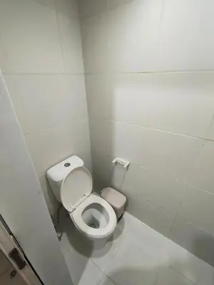 a small bathroom with a toilet in a stall at Studio City Staycation in Manila