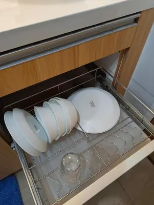 a drawer with two white dishes in a cabinet at Studio City Staycation in Manila