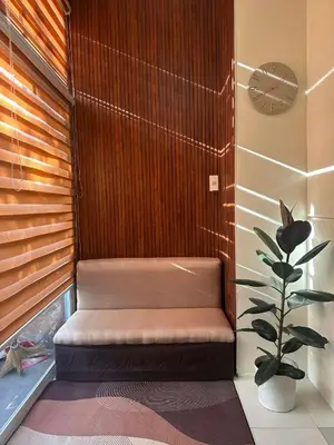 a bench in a room with a plant and a clock at Cozy Loft Unit in Manila in Manila
