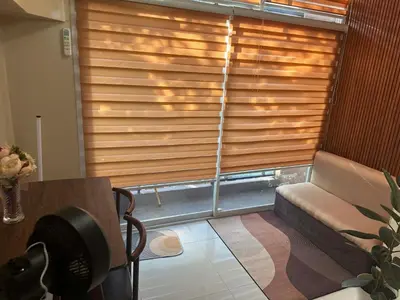 a room with a couch and a window with wooden blinds at Cozy Loft Unit in Manila in Manila