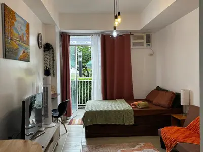 a living room with a bed and a window at Kasara T14K Cozy Abode in Manila