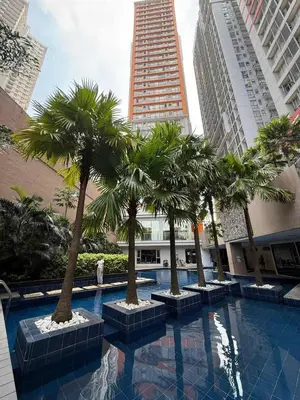 a row of palm trees in a pool in a city at Sunshine100PioneermMandaluyong PoolGymBilliardsPlaygroundTVWifi in Manila