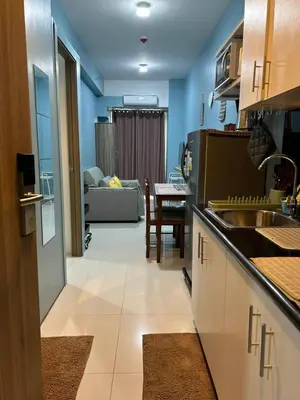 a kitchen and living room with a couch and a table at MK's place in Manila