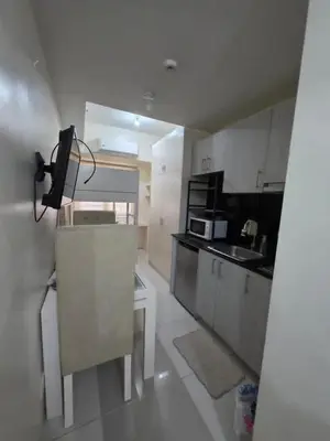 a small kitchen with a sink and a microwave at Condotels in Sucat Road in Manila