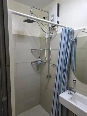 a bathroom with a shower and a sink at Condotels in Sucat Road in Manila