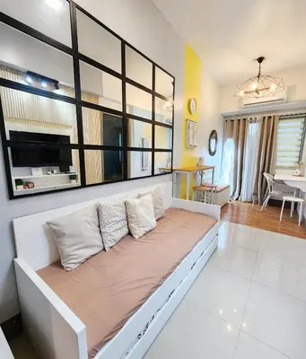 a large white couch in a living room at Cozy Family Suite at Fame Residences Tower 2 Mandaluyong in Manila