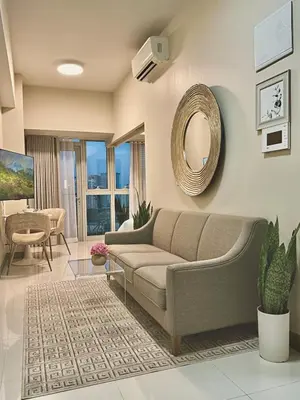 a living room with a couch and a mirror at Uptown Parksuites Sun scenic city escape 22T in Manila