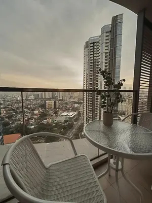 a table and chairs on a balcony with a view of a city at Uptown Parksuites Sun scenic city escape 22T in Manila