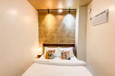 a bedroom with a bed with white sheets and pillows at Lunan by SKI - Boutique Hotel in Taytay Rizal in Taytay