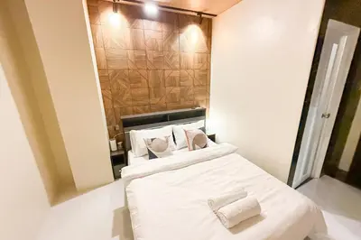 a bedroom with a bed with white sheets and pillows at Lunan by SKI - Boutique Hotel in Taytay Rizal in Taytay