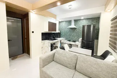 a living room with a couch and a kitchen at Lunan by SKI - Boutique Hotel in Taytay Rizal in Taytay
