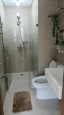 a bathroom with a shower and a toilet and a sink at 1 bedroom Condotels Across terminal 3 airport in Manila