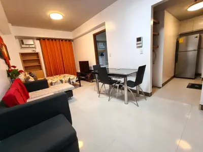 a living room with a couch and a table and chairs at 1 bedroom Condotels Across terminal 3 airport in Manila