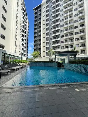 a swimming pool in front of two tall buildings at Cozy & Affordable Staycation Melrose Haven in Manila