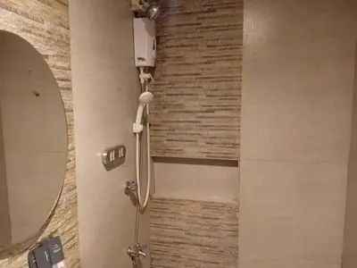 a shower in a bathroom with a mirror at Shandong Residences in Manila
