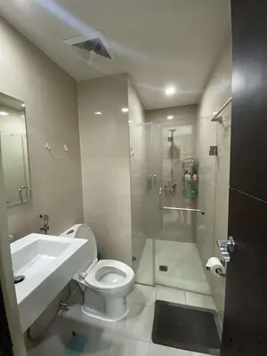 a bathroom with a shower and a toilet and a sink at Vienna's Condotel in Manila
