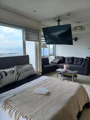 a bedroom with a large bed and a couch at Your Home Near the Airport in Manila