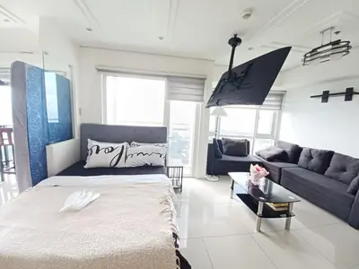 a bedroom with a large bed and a couch at Your Home Near the Airport in Manila