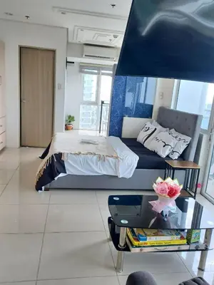 a bedroom with a bed and a glass table at Your Home Near the Airport in Manila