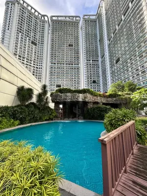 a swimming pool in front of some tall buildings at Roomi Stays Acqua Private Residences in Manila
