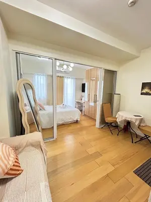 a large room with a bed and a mirror at Roomi Stays Acqua Private Residences in Manila