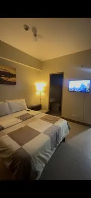a bedroom with a bed and a flat screen tv at Tala Vera condotel at Newport Pasay in Manila
