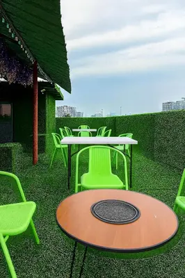 a table and green chairs on a patio with a table and chairs at T1 Stay Airport Residences - Tower A in Manila