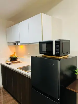 a kitchen with a microwave on top of a refrigerator at Prime Makati CBD Condo with Fast WiFi in Manila