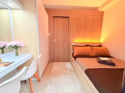 a small bedroom with a bed and a desk at Bayshore Getaway Condotel by Clowie in Manila