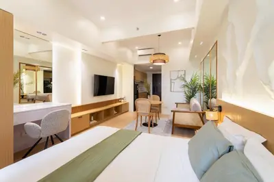 a bedroom with a bed and a living room at Luxury 1 BR City View in Park Mckinley West Fast Wi-Fi Washer Dryer in Manila