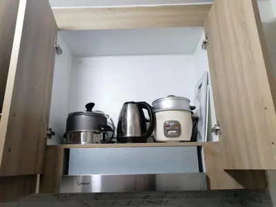 a kitchen with two pots and pans on a shelf at Classy Stay in Manila