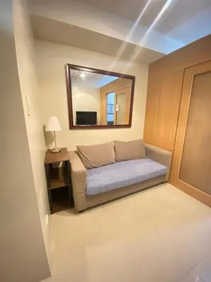 a small bedroom with a bed and a mirror at Budget Condo in Mall Of Asia in Manila
