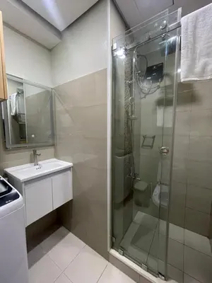 a bathroom with a glass shower and a sink at Shore 2 Residences Entire Condo in Pasay City Near SM Mall of Asia in Manila
