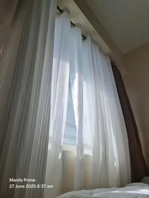 a window with white curtains in a bedroom at 1586 Shore Residences tower C2 in Manila
