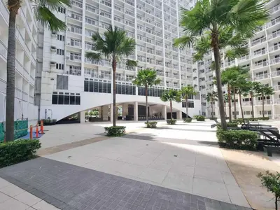 a large building with palm trees in front of it at 1586 Shore Residences tower C2 in Manila