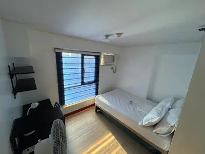 a small bedroom with a bed and a window at Ports crib in Manila