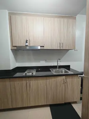 a kitchen with wooden cabinets and a sink at SHORe 2 TOWER 3 UNIT 746 in Manila