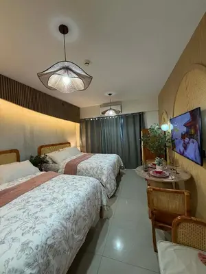 a hotel room with two beds and a table at Twin Bed 1BR w Balcony with WiFi Netflix at Shore2 T1 near MOA and NAIA Airport in Manila
