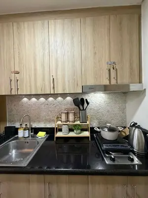 a kitchen with a sink and a stove and cabinets at Twin Bed 1BR w Balcony with WiFi Netflix at Shore2 T1 near MOA and NAIA Airport in Manila