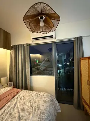 a bedroom with a large window and a ceiling fan at Twin Bed 1BR w Balcony with WiFi Netflix at Shore2 T1 near MOA and NAIA Airport in Manila