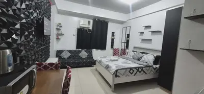 a room with a bed and a couch and a chair at Vienna Condotel at 101 Newport Blvd in Manila