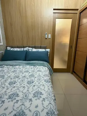 a bedroom with a bed with blue pillows and a door at Neo-Classic 1BR with WiFi Netflix at Shell Res near MOA and NAIA Airport in Manila