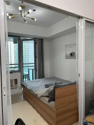 a bedroom with a bed with a glass wall at Anasa Suites in Manila