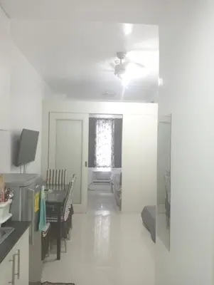 a white living room with a table and a window at Sea Residences Tower EF Rose in Manila