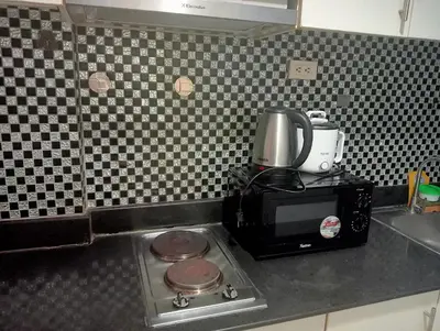 a kitchen counter with a coffee maker on top of a microwave at Sea Residences Tower EF Rose in Manila