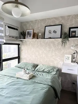 a bedroom with a bed with a towel on it at Cozy Nature-Inspired Studio Unit in Cubao in Manila
