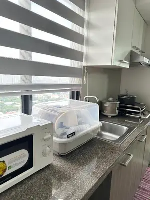 a kitchen counter with a microwave and a sink at Cozy Nature-Inspired Studio Unit in Cubao in Manila