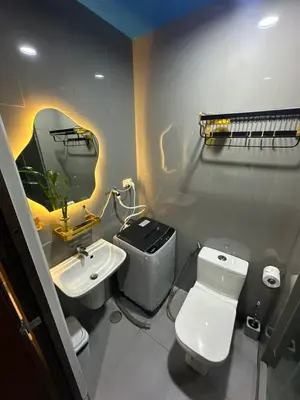a bathroom with a white toilet and a sink at Sunbeam - Lush Residence in Manila