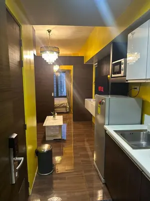 a kitchen with a refrigerator and a table in it at Sunbeam - Lush Residence in Manila